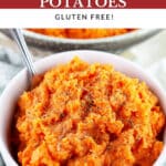 Savory mashed sweet potatoes in white bowl with fork.