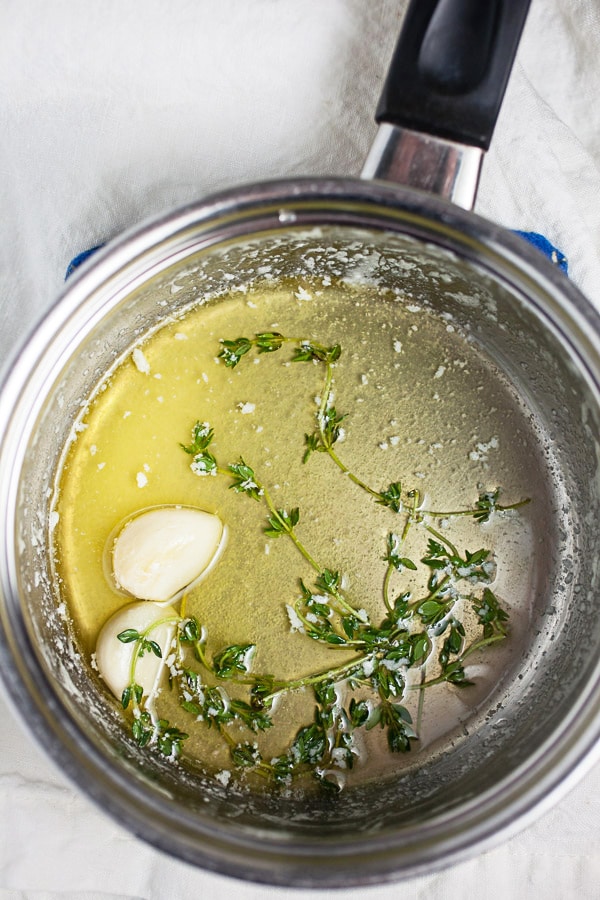 Melted butter, garlic cloves, and thyme in sauce pan.