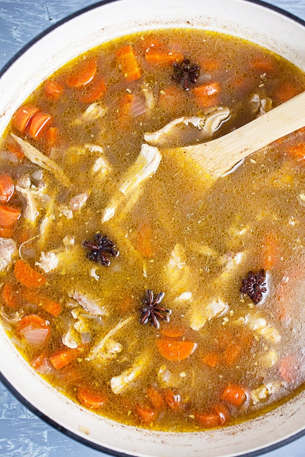 Chicken soup broth with star anise in Dutch oven.