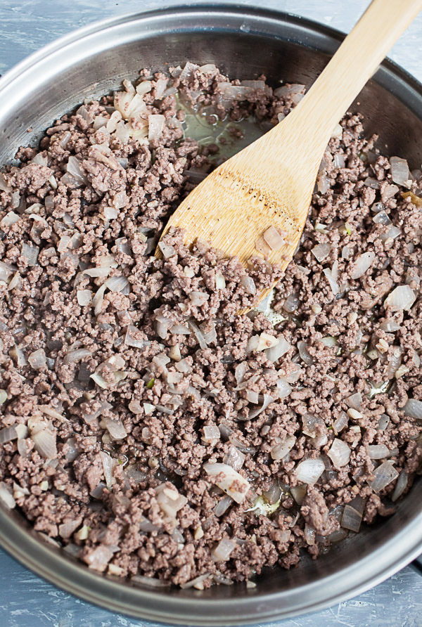 Ground beef sautéed with garlic and onions in skillet.