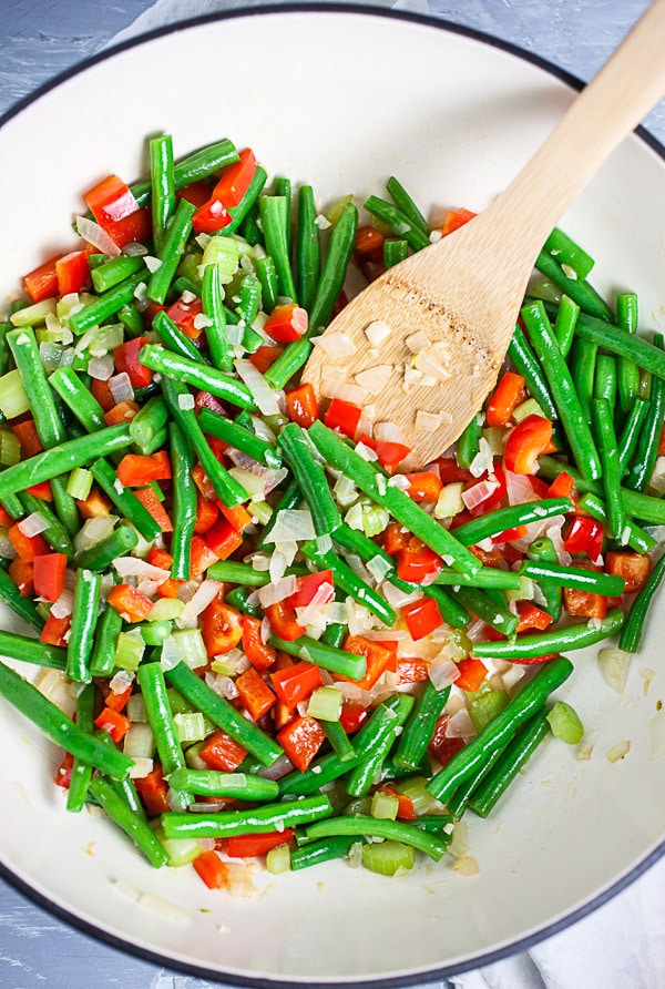 Garlic, onions, celery, red bell peppers, and green beans sautéed in Dutch oven.