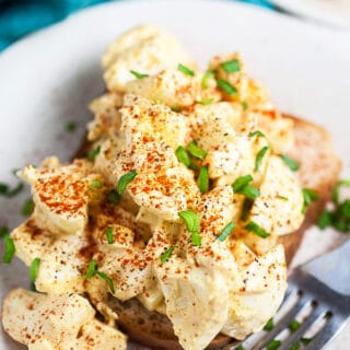 Mustard egg salad on white plate with fork.