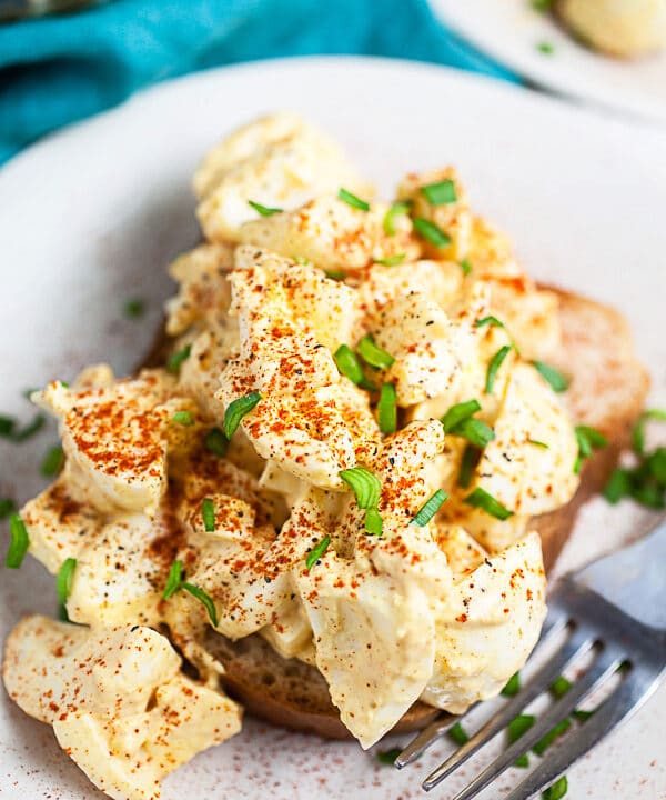 Mustard egg salad on white plate with fork.