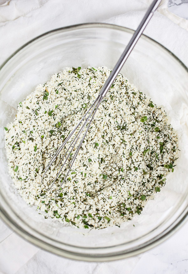 Homemade ranch seasoning in small glass bowl with whisk.