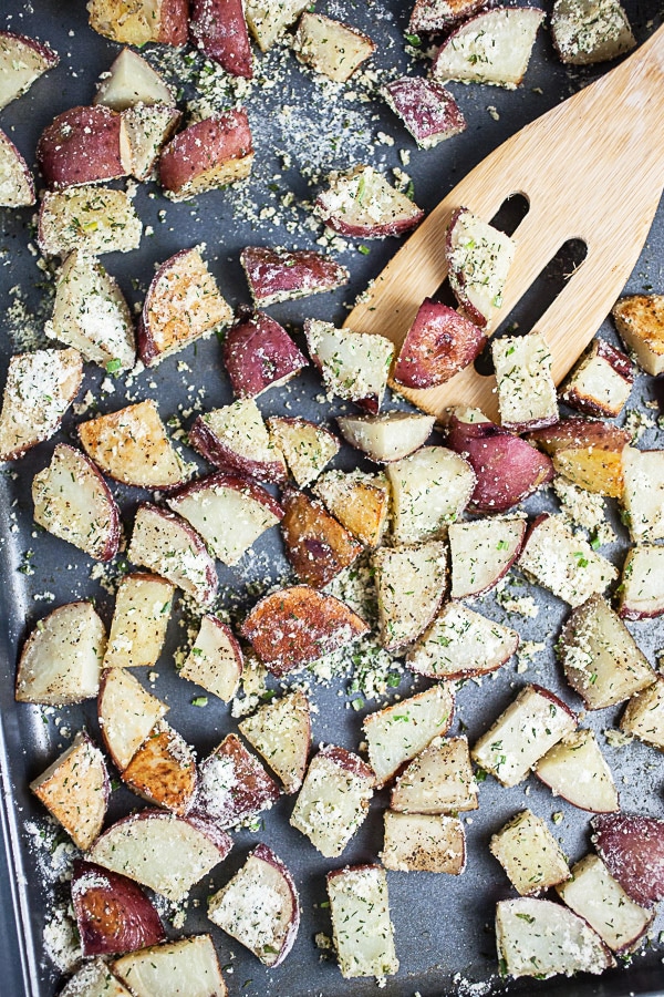 Roasted potatoes tossed with ranch seasoning on metal baking sheet.