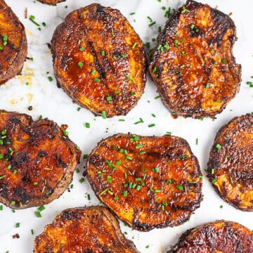 Sliced BBQ sweet potatoes on white surface.