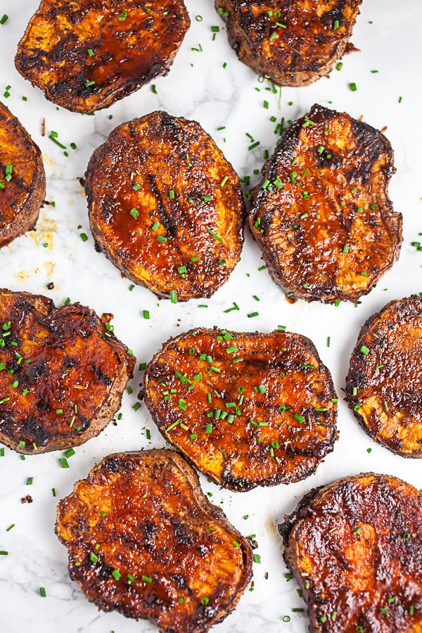 Sliced BBQ sweet potatoes on white surface.