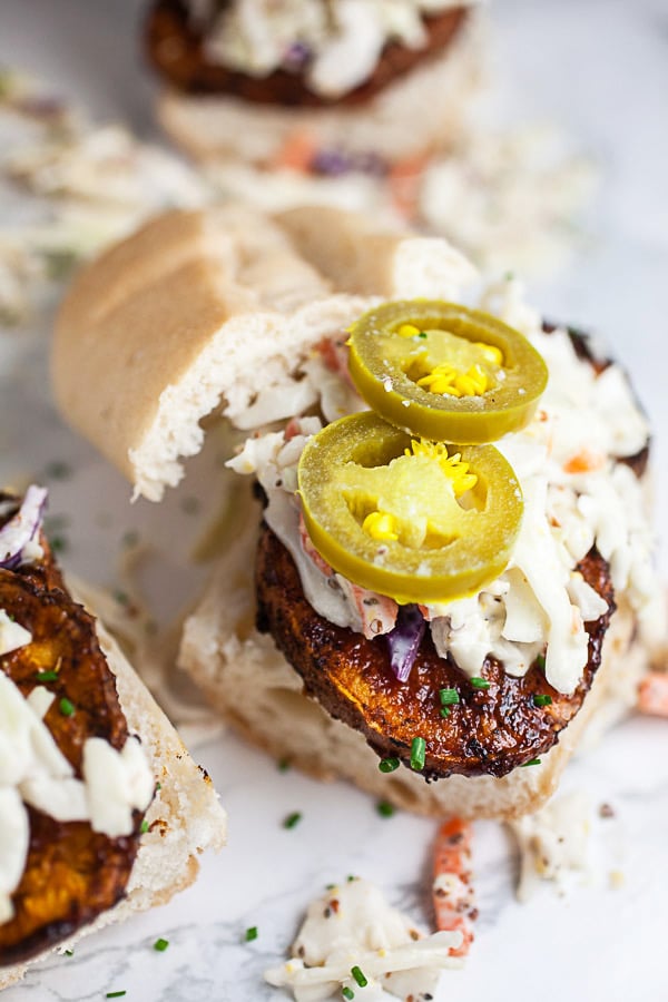 BBQ sweet potatoes on bun with coleslaw and pickled jalapenos.