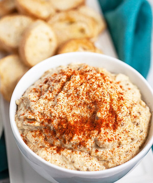 Baba ghanoush with topped with smoked paprika next to crostini.