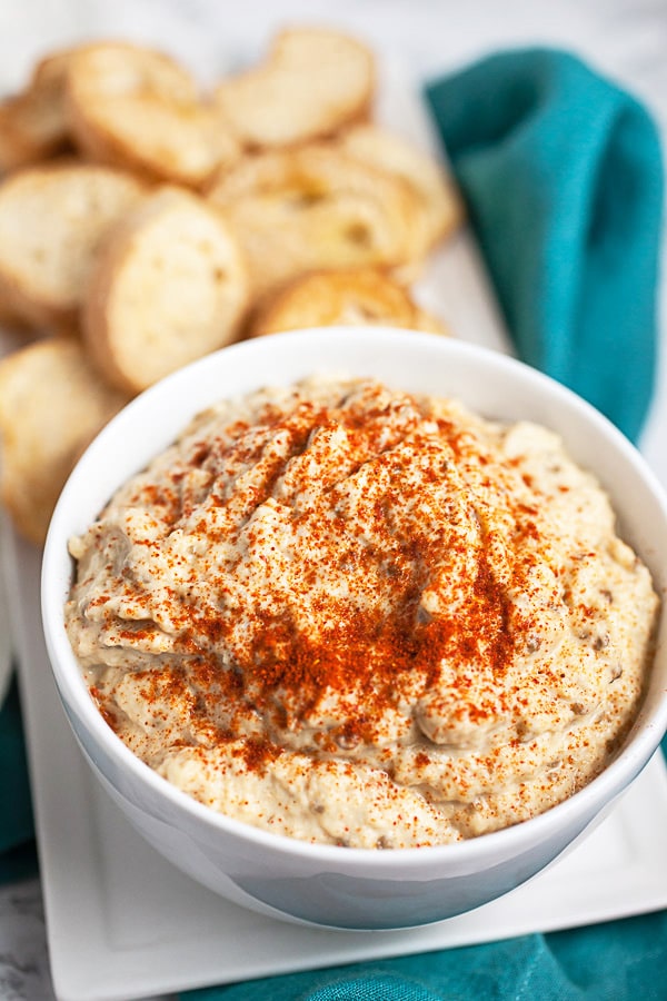 Baba ghanoush with topped with smoked paprika next to crostini.