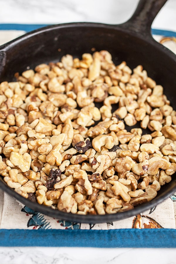 Toasted walnuts in small cast iron skillet.