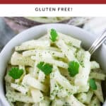 Kohlrabi slaw in white bowl with fork garnished with fresh cilantro.
