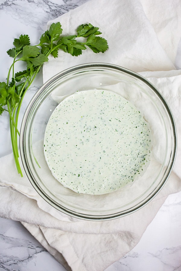 Creamy cilantro lime dressing in small glass bowl.