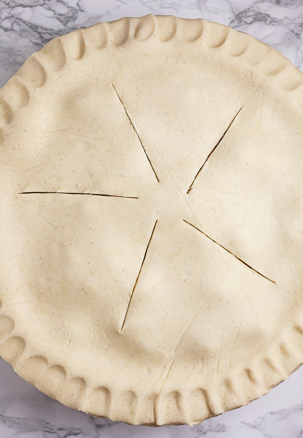 Unbaked pie with crimped crust in pie plate.