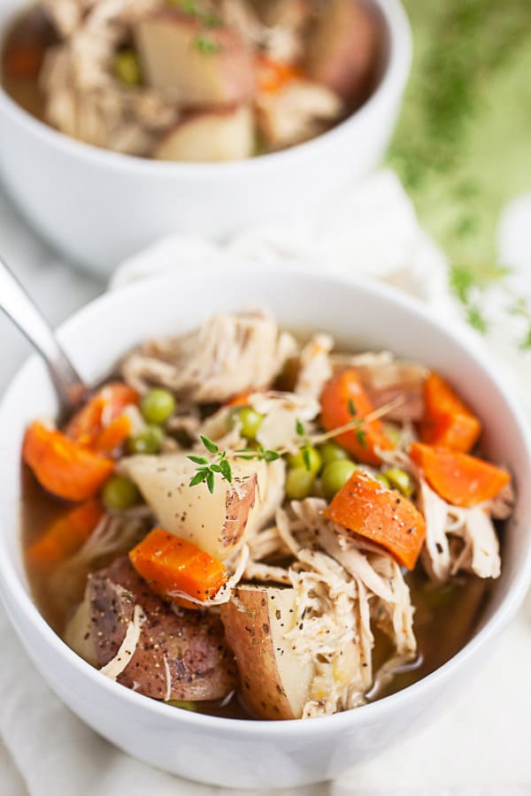 Chicken potato soup with thyme in small white bowls.