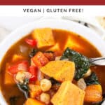 Sweet potato kale soup in white bowl with spoon.