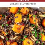 Harvest wild rice butternut squash salad in ceramic bowl garnished with minced chives.