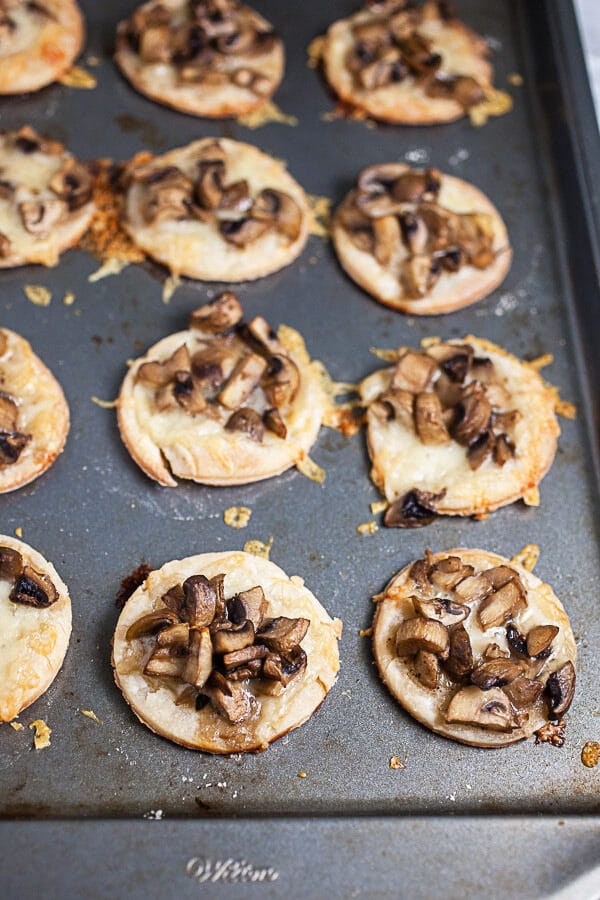 Baked mushroom gruyere tartlets on metal baking sheet.