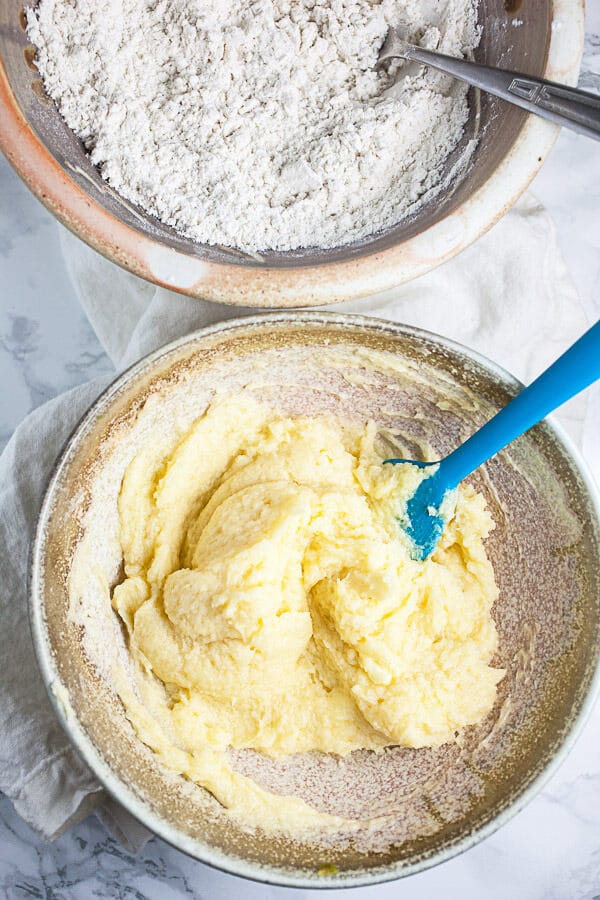 Wet and dry sugar cookie ingredients in two separate ceramic bowls.