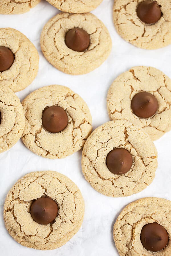 Baked peanut butter blossoms on white surface.