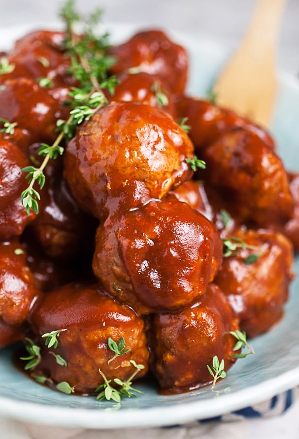 BBQ turkey meatballs garnished with thyme in blue bowl.