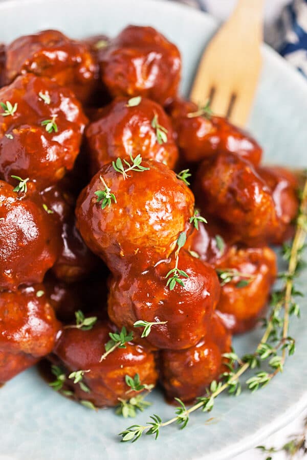 BBQ turkey meatballs garnished with thyme in blue bowl.