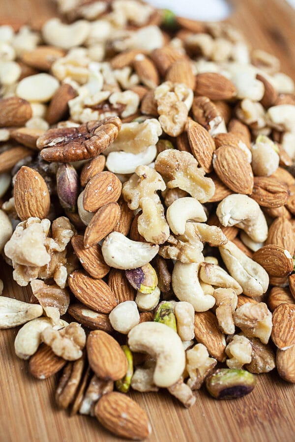 Mixed nuts on wooden cutting board.