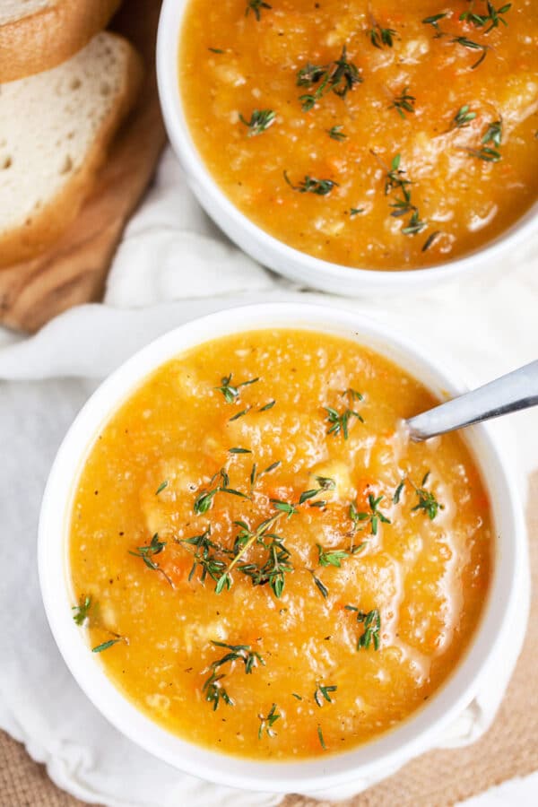 Winter root vegetable soup in small white bowls garnished with thyme.