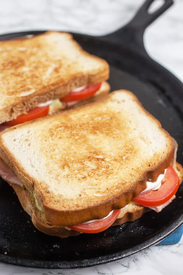 Italian grilled cheese sandwiches toasting on cast iron griddle.