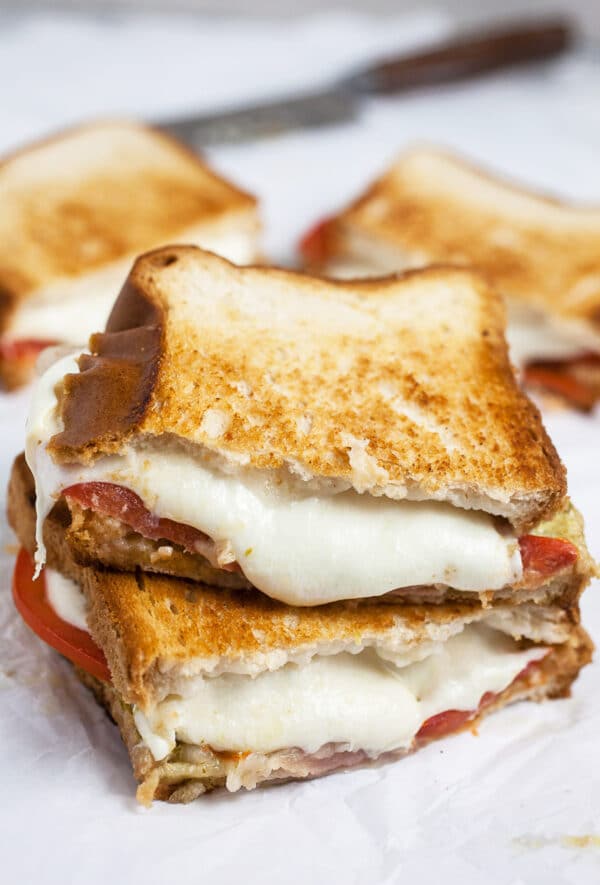 Italian mozzarella grilled cheese sandwich cut in half and stacked.