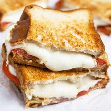 Italian mozzarella grilled cheese sandwich cut in half and stacked.