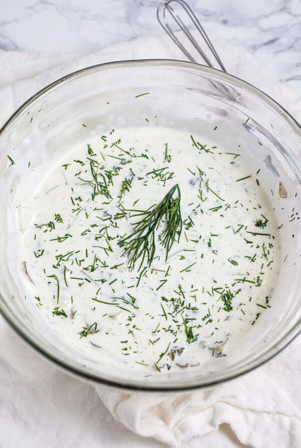 Homemade tartar sauce with fresh dill in small glass bowl.