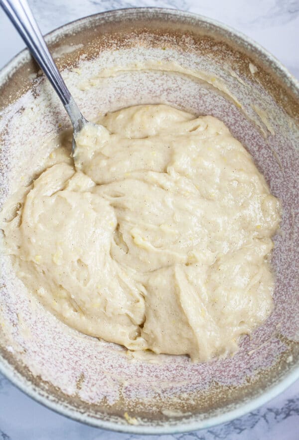 Doughnut batter in ceramic bowl with spoon.