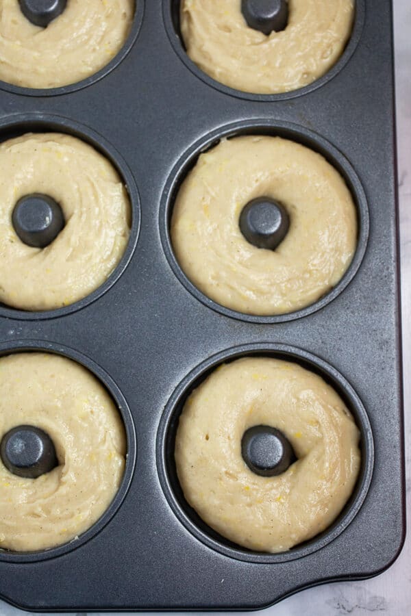 Unbaked batter in metal doughnut pan.