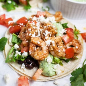 Cajun shrimp tacos with black beans and avocado sauce.