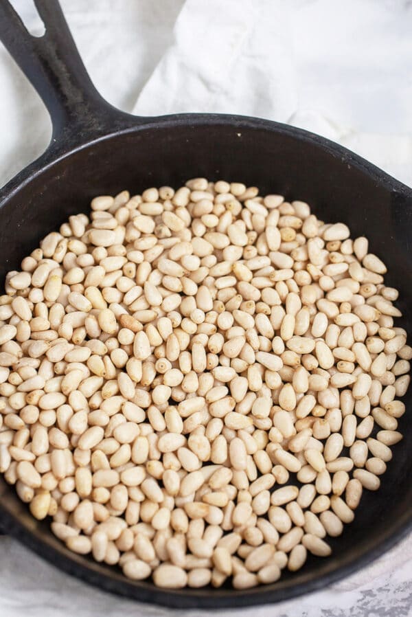 Toasted pine nuts in small cast iron skillet.