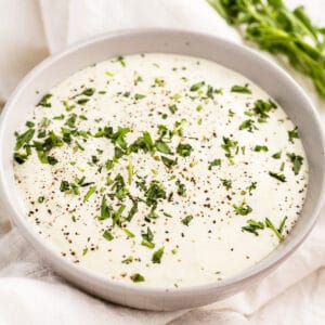 Creamy Lemon Tarragon Sauce with minced tarragon in small bowl.