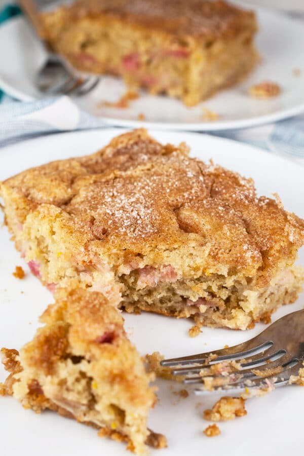 Buttermilk gluten free rhubarb cake on small white plate with fork.