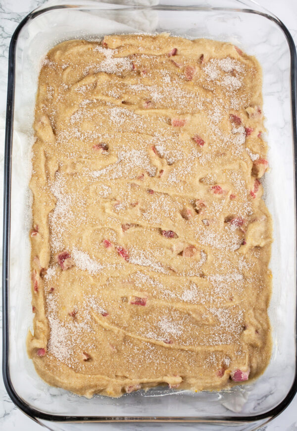 Unbaked rhubarb cake in rectangular glass cake pan.