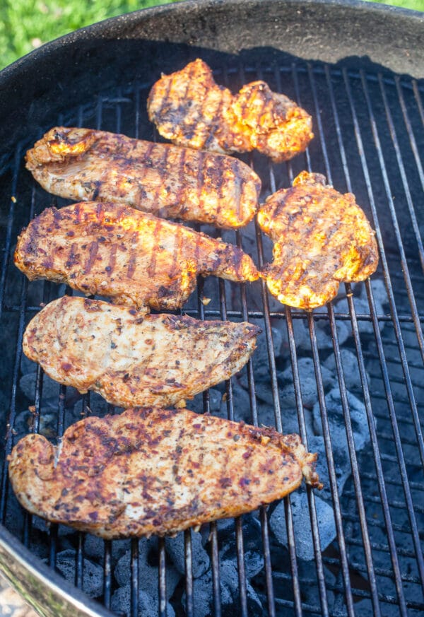 Cooked chicken breasts on Weber grill.