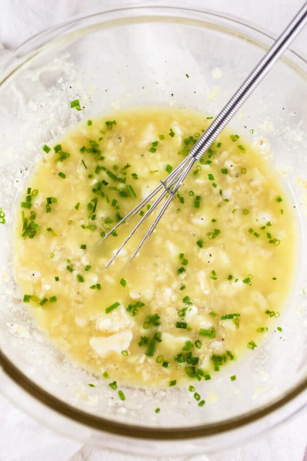 Feta vinaigrette in small glass bowl with whisk.