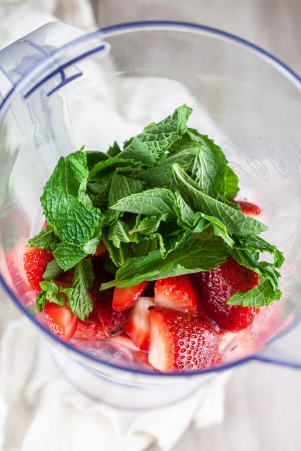 Fresh strawberries and mint in blender.