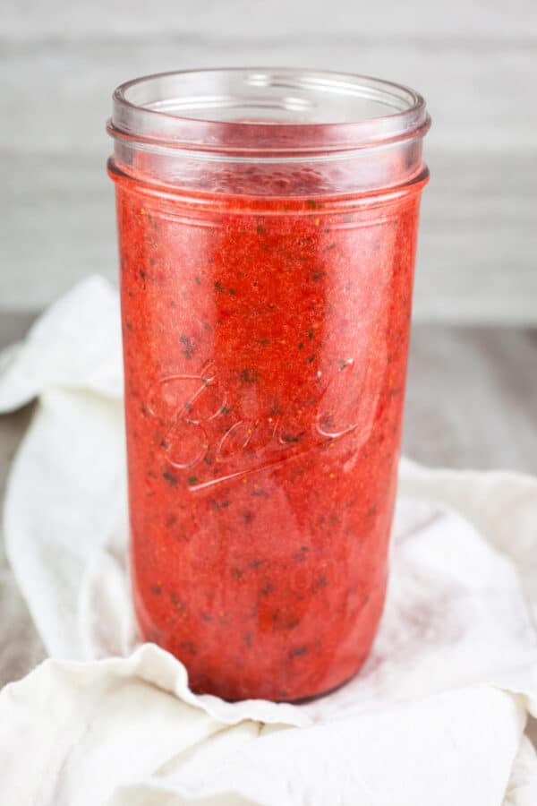 Strawberry mint puree in tall glass mason jar.