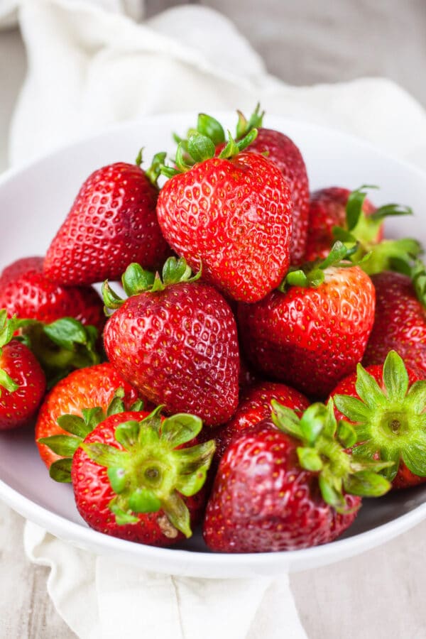 Fresh strawberries in white bowl.