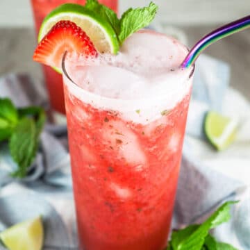 Virgin strawberry mojito mocktail with metal straw in tall glass.