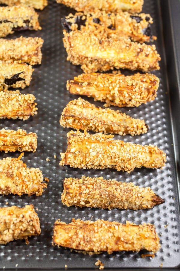 Cooked air fryer eggplant fries on baking sheet.
