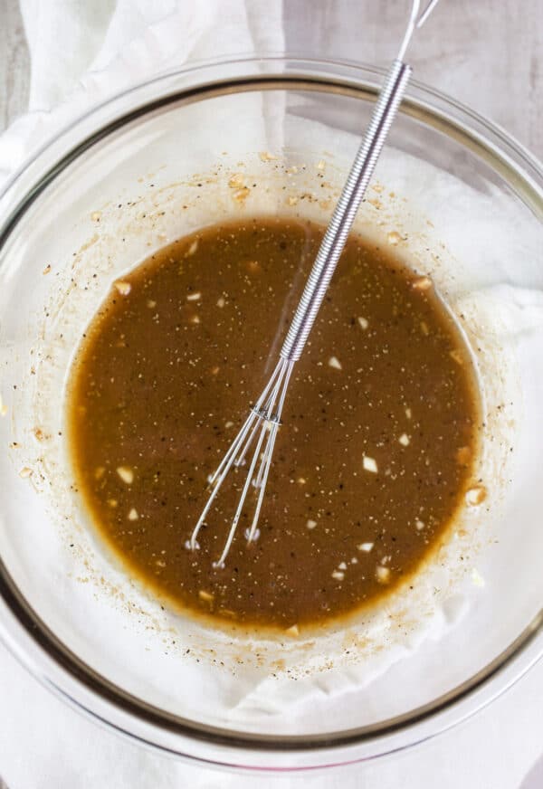 Balsamic vinaigrette dressing in glass bowl with whisk.