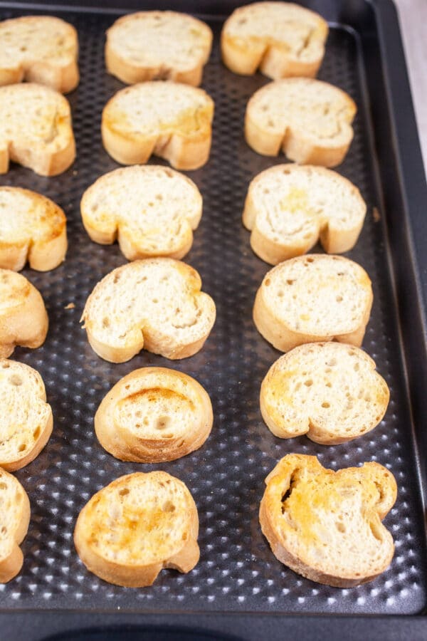 Toasted crostini on baking sheet.