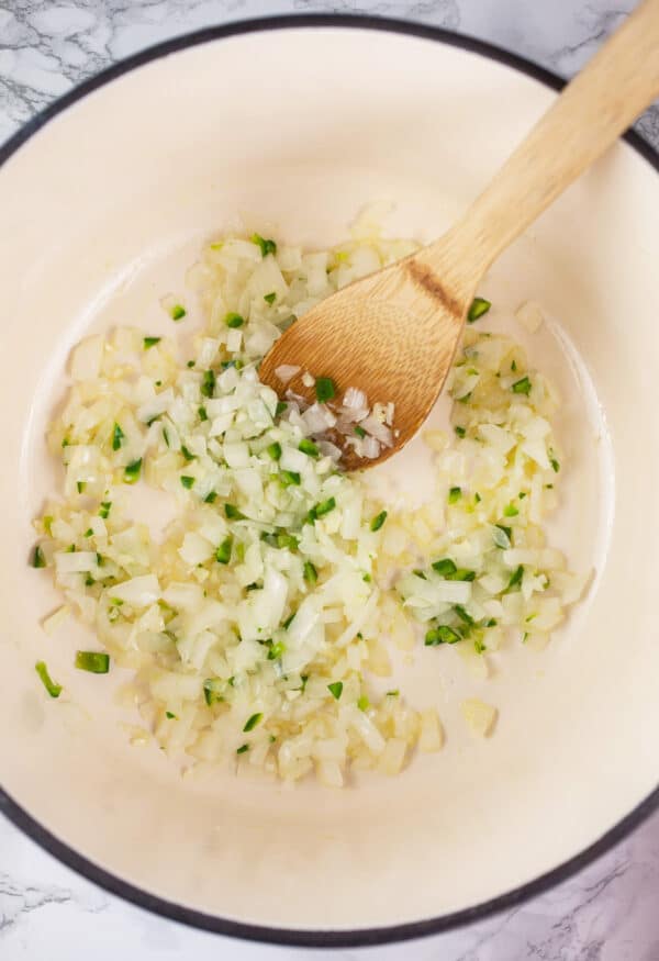 Garlic, onions, and jalapeno peppers sautéed in white cast iron Dutch oven.