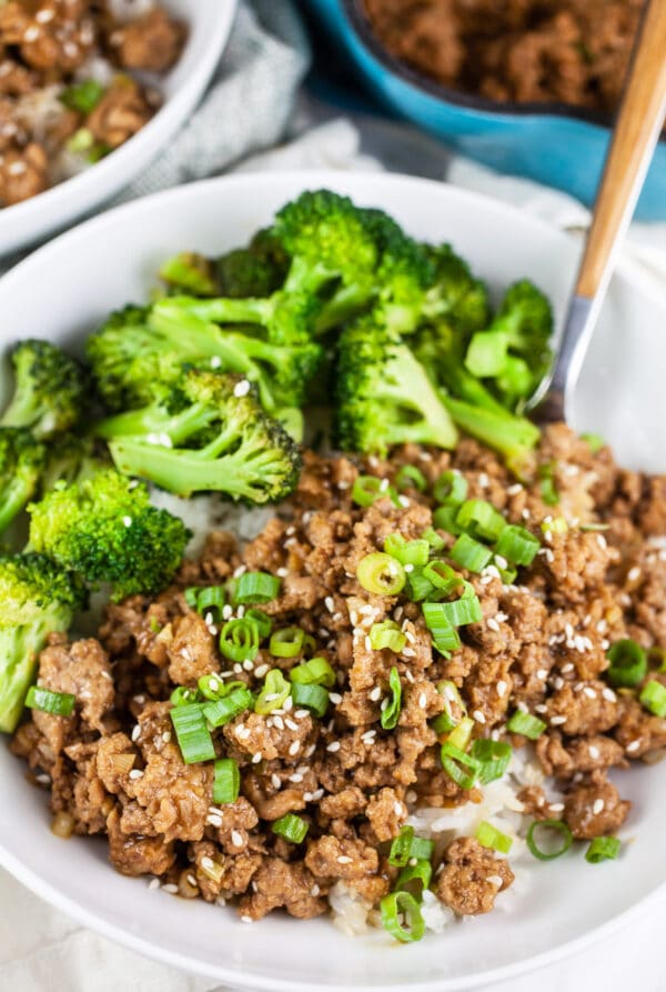 Ground teriyaki turkey with broccoli on rice in white bowl.